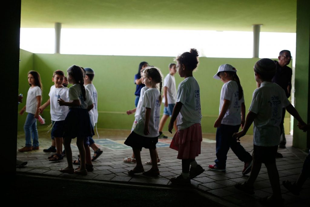 Israeli children walk in a school on the first day of the school year in Kibbutz Saad