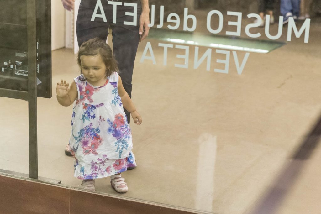 bambina guarda stupita i resti romani all'ingresso del museo del campanone;