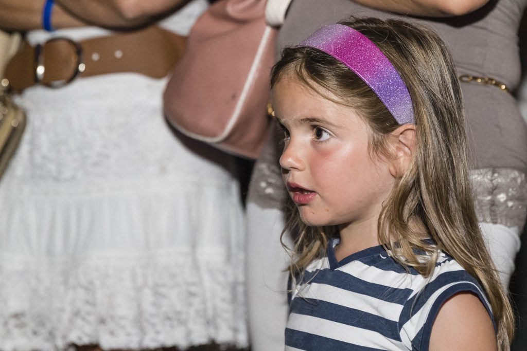 bambini stupiti davanti allo spettacolo di un giocoliere;