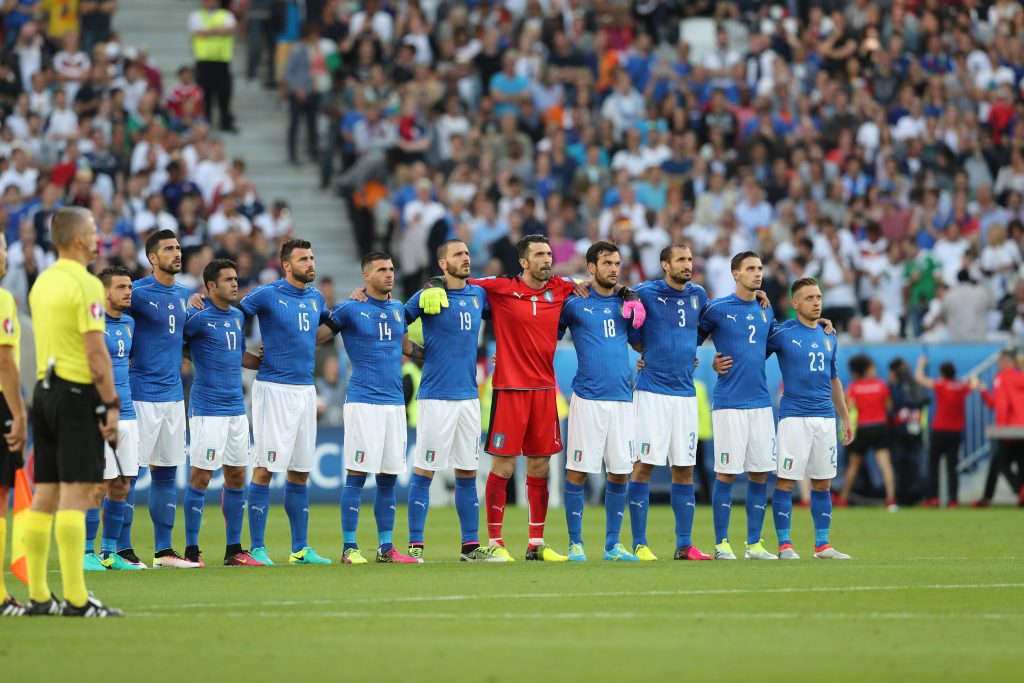 Italian players stand on the pitch to honor the victims of the attack in a Dhaka's restaurant, Bangladesh, during the Euro 2016 quarterfinal soccer match between Germany and Italy, at the Nouveau Stade in Bordeaux, France, Saturday, July 2, 2016. (ANSA/AP Photo/Thanassis Stavrakis)