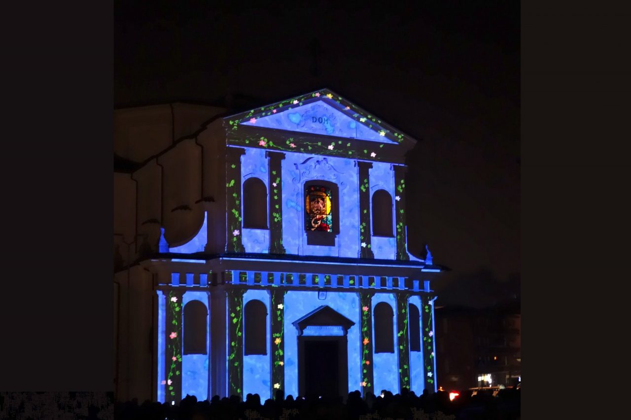 Luci e memoria, sulla chiesa di Cene si proiettano le immagini dei defunti