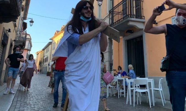 Si traveste da Gesù Cristo e sfila con la croce per festeggiare i 33 anni
