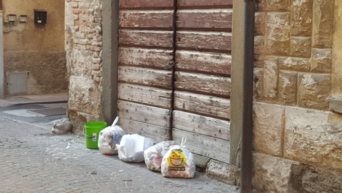 Espone i sacchi dei rifiuti, ma non sono differenziati: la polizia locale di Romano lo obbliga a separarli sul posto