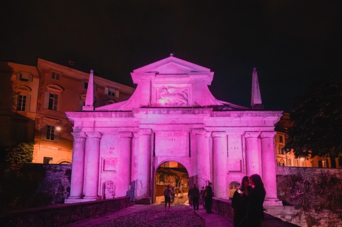 Porta San Giacomo si illumina di magenta per la giornata dedicata alle patologie eosinofile