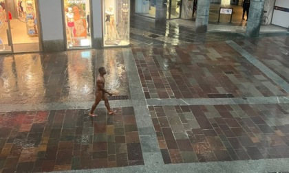 Un uomo completamente nudo sotto la pioggia in via XX Settembre a Bergamo