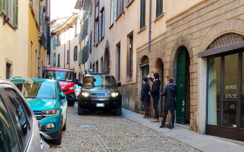 Via San Tomaso a Bergamo, le auto sui marciapiedi in una strada stretta: pedoni a rischio